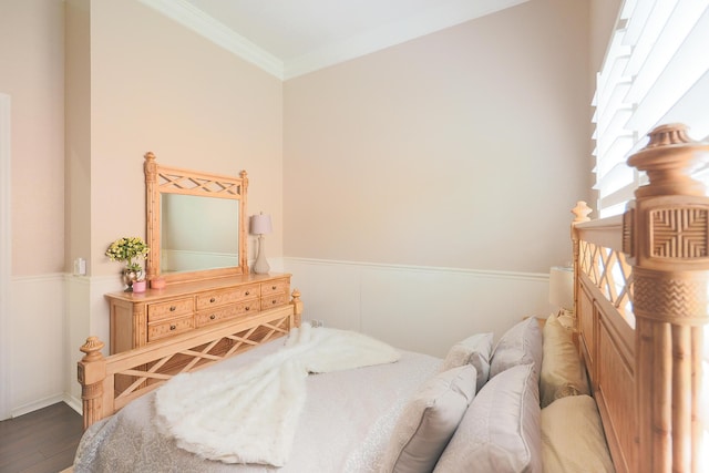 bedroom with ornamental molding, light wood-style flooring, a ceiling fan, and wainscoting