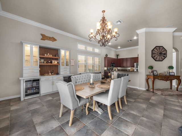 1289 Beacon Cir, Wellington, FL 33414 - tiled dining area featuring wine cooler, ornamental molding, a chandelier, baseboards, and arched walkways