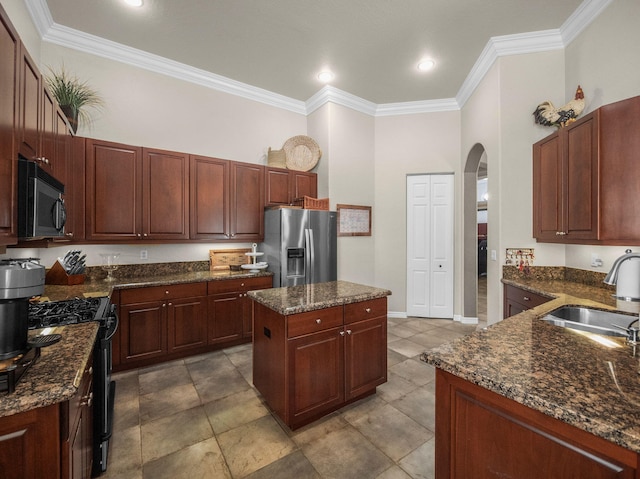 1289 Beacon Cir, Wellington, FL 33414 - kitchen with stainless steel appliances, a sink, arched walkways, ornamental molding, and a kitchen island