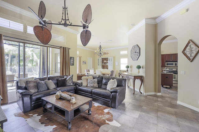 living room with baseboards, arched walkways, ornamental molding, a chandelier, and a towering ceiling