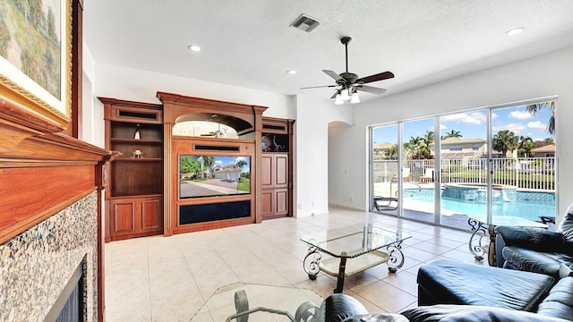 living area with recessed lighting, ceiling fan, visible vents, a textured ceiling, and arched walkways