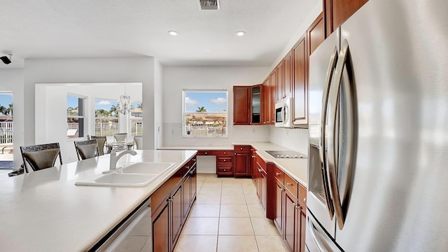 kitchen featuring light tile patterned floors, a sink, stainless steel appliances, light countertops, and recessed lighting