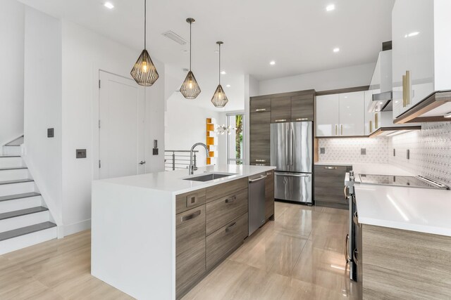 4240 NW 17th Ave, Boca Raton, FL 33431 - kitchen with stainless steel appliances, a sink, modern cabinets, light countertops, and a kitchen island with sink