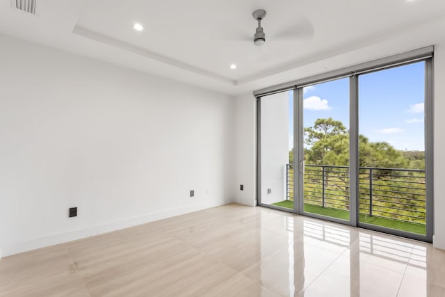 4240 NW 17th Ave, Boca Raton, FL 33431 - spare room featuring light tile patterned floors, recessed lighting, ceiling fan, a wall of windows, and a raised ceiling