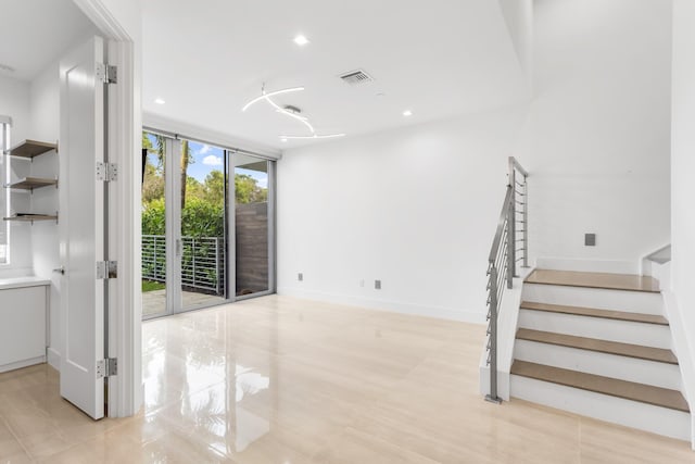 4240 NW 17th Ave, Boca Raton, FL 33431 - unfurnished living room featuring a wall of windows, light tile patterned flooring, stairway, baseboards, and recessed lighting