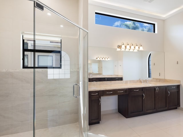 full bathroom featuring a towering ceiling, a stall shower, vanity, and tile patterned floors