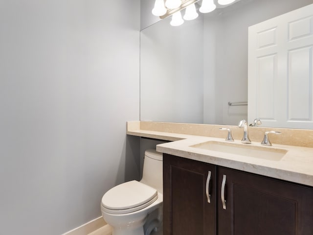 bathroom with vanity, toilet, and baseboards