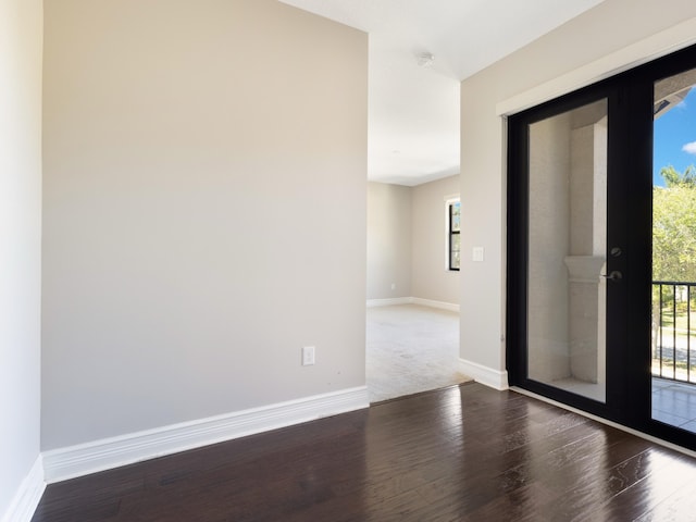 unfurnished room featuring a wealth of natural light, baseboards, and wood finished floors