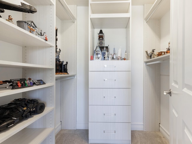 walk in closet featuring light carpet
