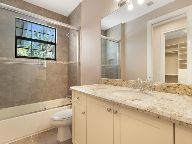 full bath with visible vents, toilet, tile patterned floors, vanity, and enclosed tub / shower combo