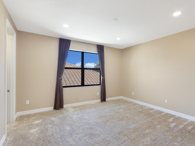 spare room featuring recessed lighting, baseboards, and carpet