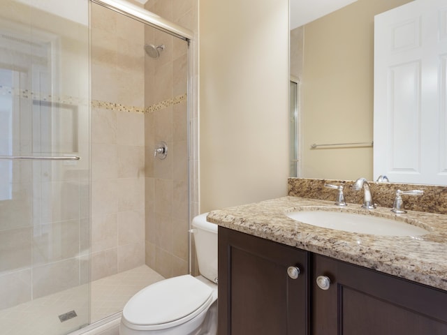 full bathroom with toilet, a stall shower, and vanity