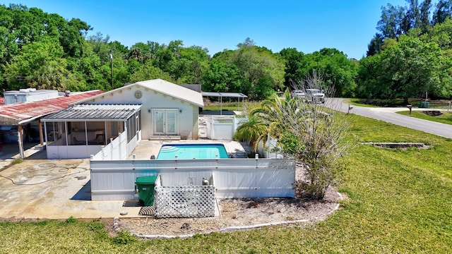 pool featuring a sunroom, fence, french doors, a yard, and a patio area