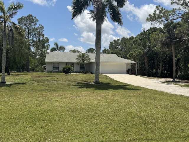 single story home with driveway, an attached garage, and a front yard