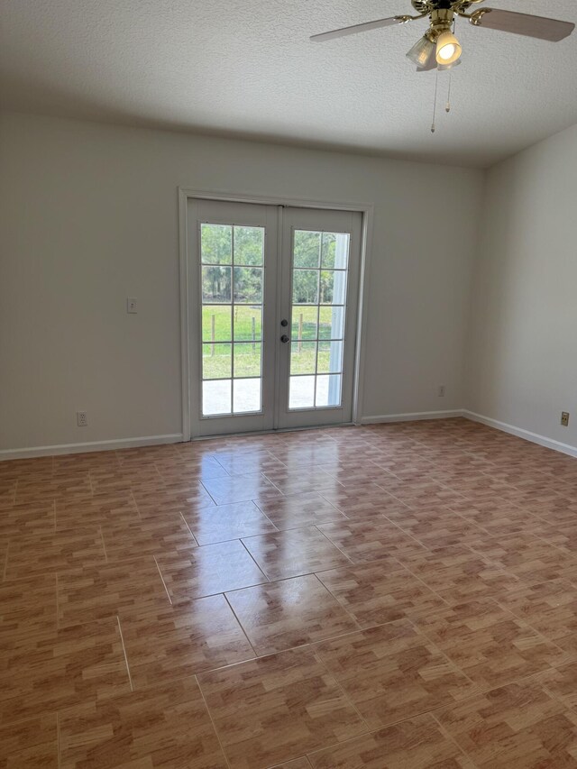 spare room featuring ceiling fan, french doors, baseboards, and a textured ceiling