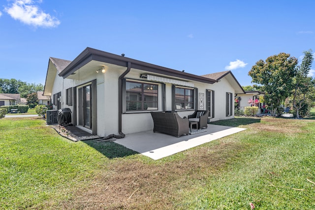 back of property with central AC unit, a lawn, a patio, and stucco siding
