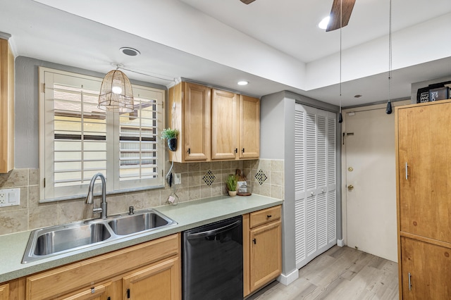 kitchen featuring light wood-style flooring, a sink, tasteful backsplash, light countertops, and dishwasher