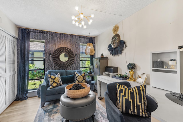 living area with wood finished floors, a textured ceiling, and a chandelier