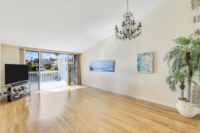 213 Ocean Dunes Cir, Jupiter, FL 33477 - living room featuring lofted ceiling, baseboards, a chandelier, a textured ceiling, and wood finished floors