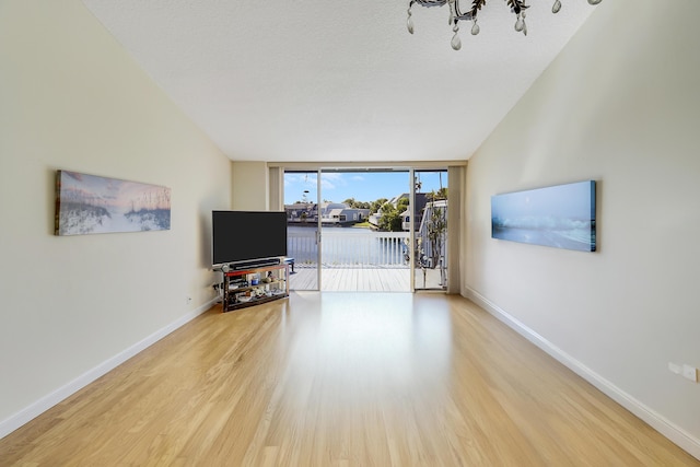 213 Ocean Dunes Cir, Jupiter, FL 33477 - living room with baseboards, a notable chandelier, wood finished floors, and expansive windows