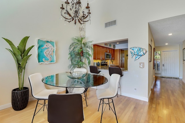 213 Ocean Dunes Cir, Jupiter, FL 33477 - dining area with baseboards, visible vents, a notable chandelier, and light wood-style floors