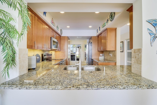 213 Ocean Dunes Cir, Jupiter, FL 33477 - kitchen with light stone countertops, stainless steel appliances, recessed lighting, a sink, and backsplash