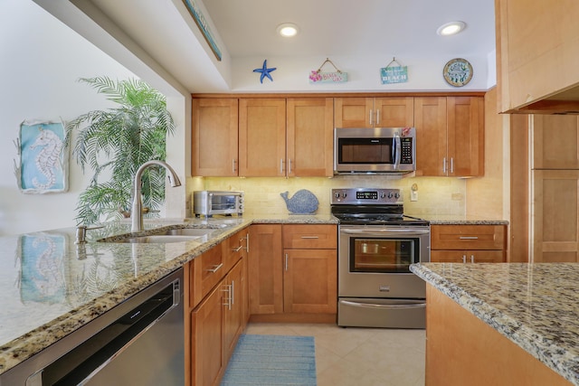 213 Ocean Dunes Cir, Jupiter, FL 33477 - kitchen featuring stainless steel appliances, a sink, light stone counters, backsplash, and light tile patterned floors