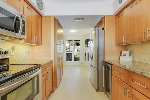 213 Ocean Dunes Cir, Jupiter, FL 33477 - kitchen with visible vents, stainless steel appliances, brown cabinetry, and light stone counters