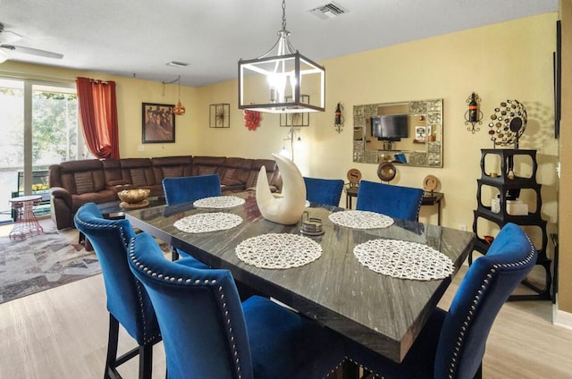dining area with visible vents, wood finished floors, and a ceiling fan