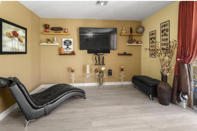 sitting room featuring visible vents, baseboards, and wood finished floors