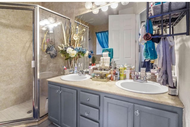 full bathroom featuring a sink, double vanity, and a shower stall
