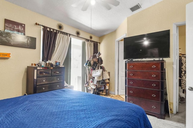 carpeted bedroom with visible vents and ceiling fan