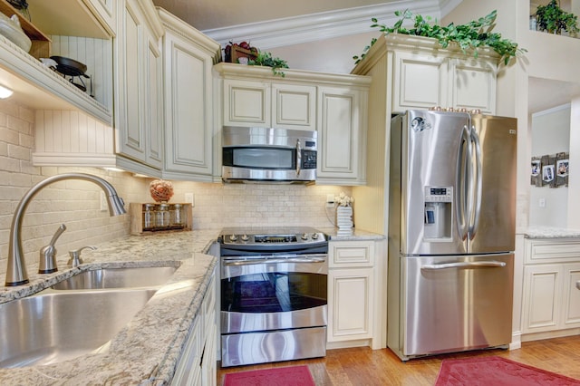 12693 Coral Breeze Dr, Wellington, FL 33414 - kitchen featuring light wood finished floors, ornamental molding, appliances with stainless steel finishes, and a sink