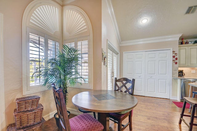 12693 Coral Breeze Dr, Wellington, FL 33414 - dining space with light wood finished floors, visible vents, baseboards, and ornamental molding