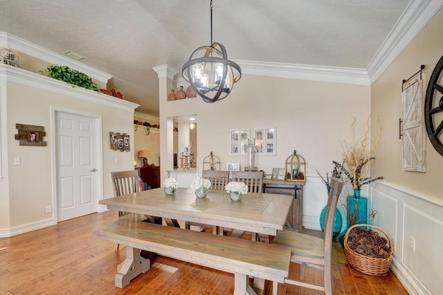 12693 Coral Breeze Dr, Wellington, FL 33414 - dining area with crown molding, a decorative wall, a notable chandelier, and light wood finished floors