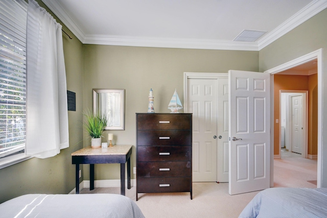 carpeted bedroom featuring a closet, baseboards, visible vents, and crown molding