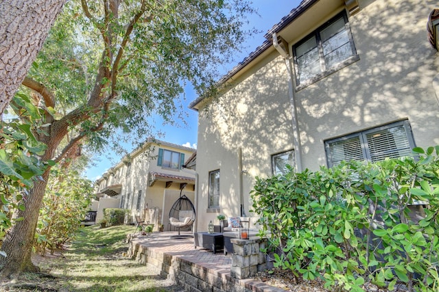 back of property featuring a patio area and stucco siding