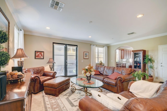 living area with recessed lighting, arched walkways, visible vents, and ornamental molding