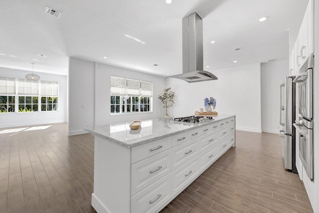 kitchen with a center island, appliances with stainless steel finishes, plenty of natural light, and island exhaust hood