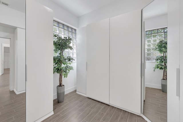interior space with visible vents, baseboards, plenty of natural light, and wood finish floors