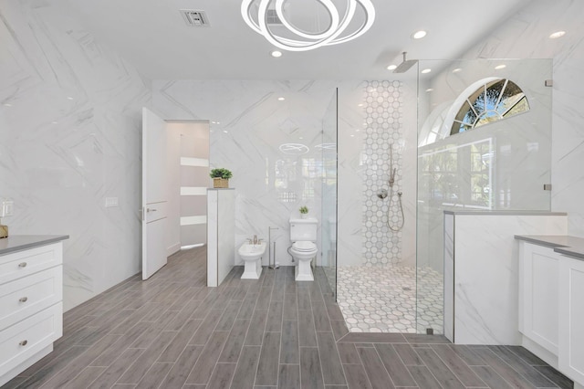 bathroom with vanity, visible vents, wood finished floors, a marble finish shower, and a bidet