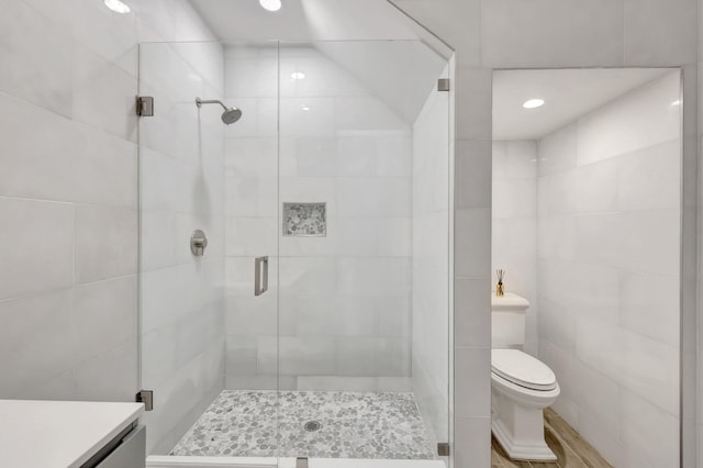 bathroom featuring toilet, recessed lighting, a stall shower, and vanity