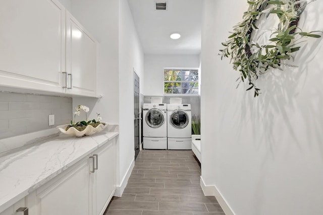 laundry room featuring visible vents, baseboards, laundry area, wood finished floors, and washing machine and dryer