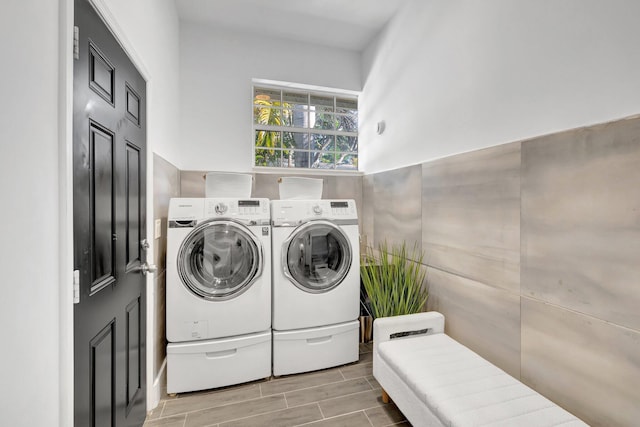 laundry room with laundry area, separate washer and dryer, and wood tiled floor
