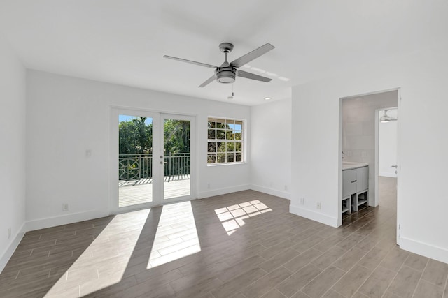 empty room featuring french doors, baseboards, a ceiling fan, and wood finished floors