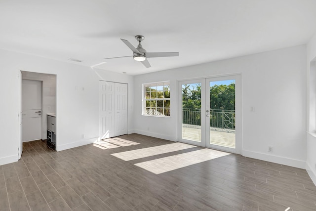 unfurnished bedroom with access to exterior, wood finished floors, and baseboards