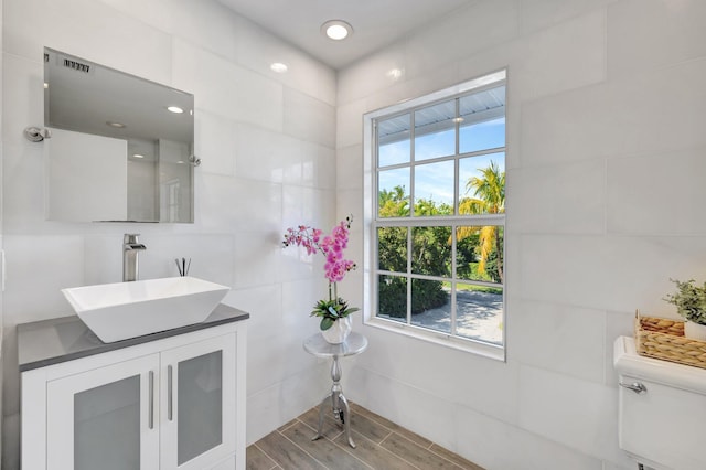 bathroom with vanity, toilet, and wood finished floors