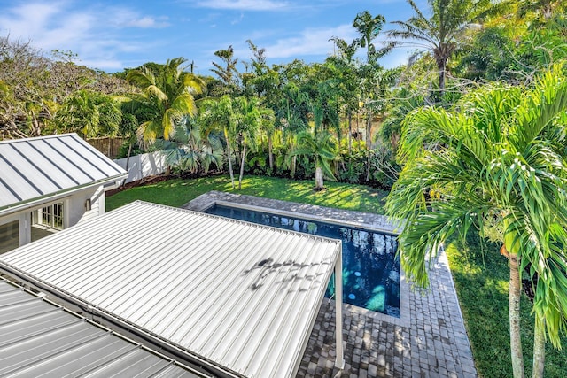 view of swimming pool featuring a fenced backyard, a patio, and a lawn