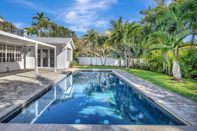 view of swimming pool featuring a patio, a fenced in pool, fence, and a lawn