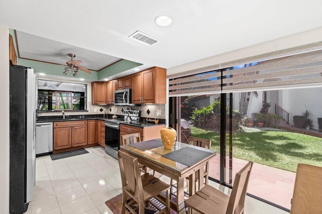 kitchen with a sink, crown molding, ceiling fan, and appliances with stainless steel finishes